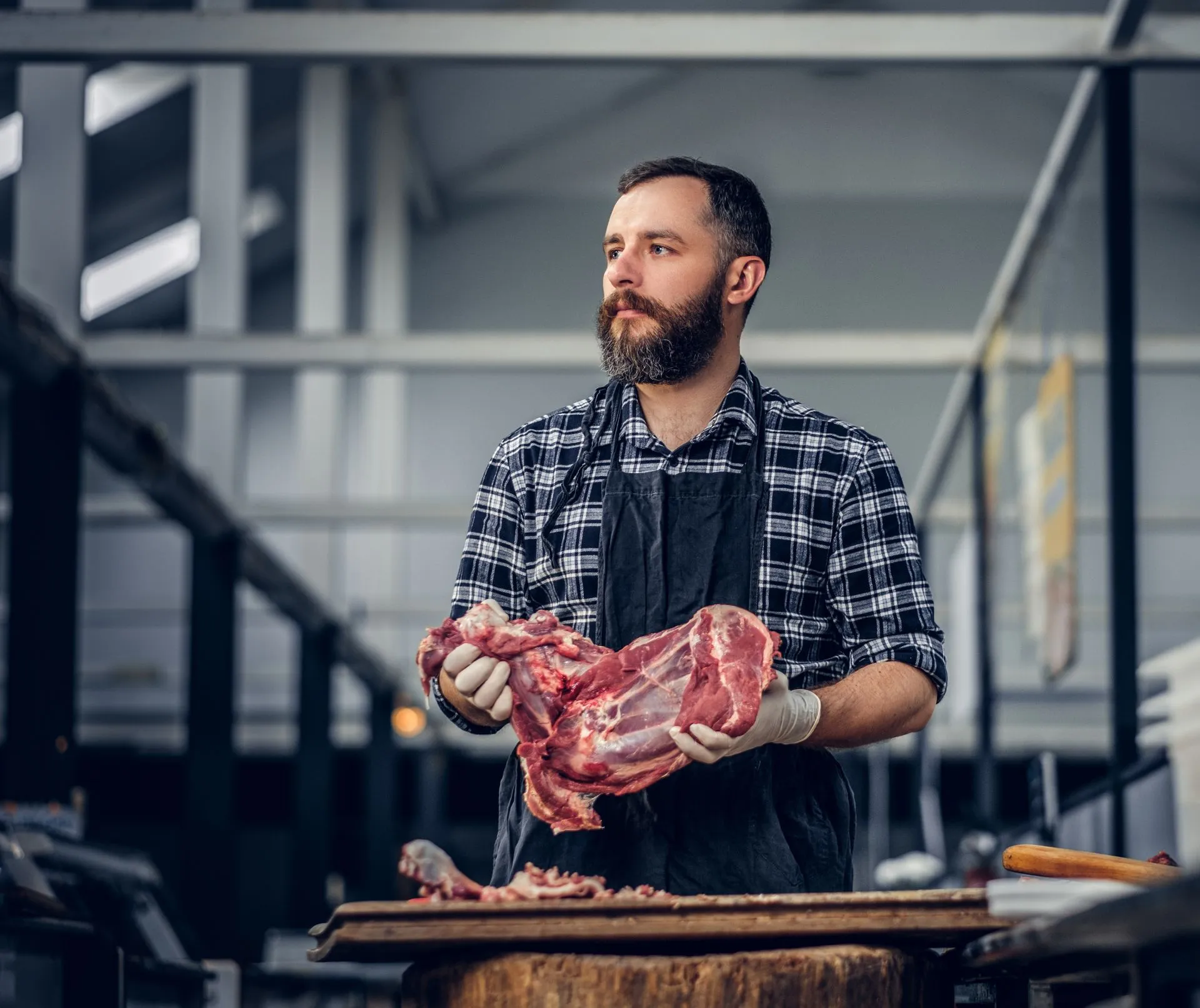 Bearded butcher holding a fresh cut of meat